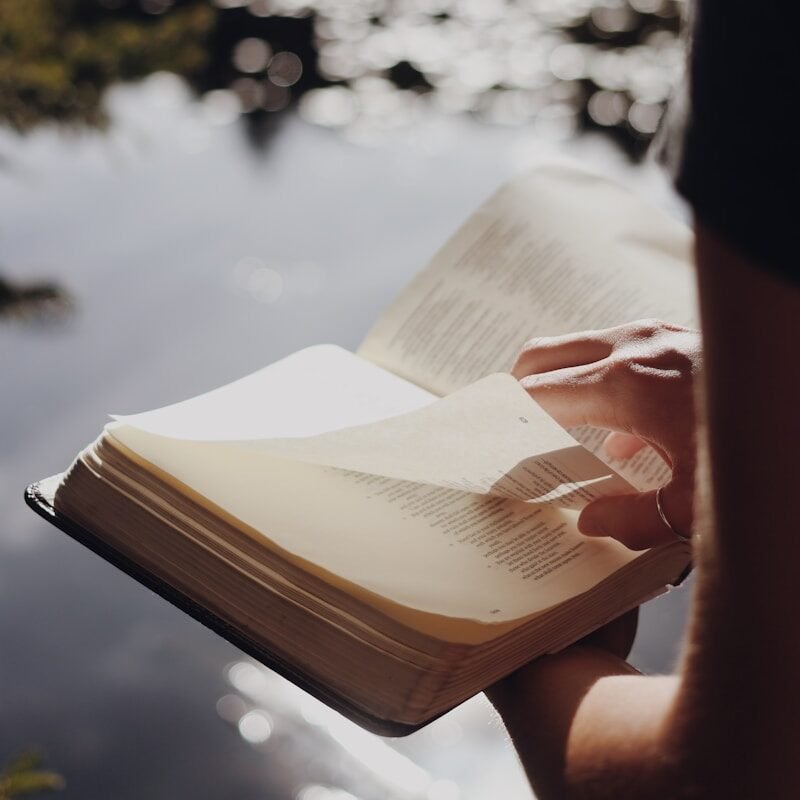 person in black long sleeve shirt holding book